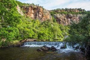 a waterfall in front of a mountain with trees at Rivendell Trout Estate in Lydenburg