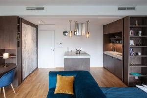 a living room with a blue couch and a kitchen at Cosy Design Apartment IV in Brno