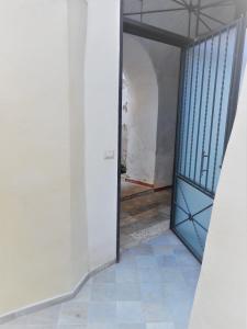 un pasillo vacío con una puerta azul en un edificio en Giulia, en Gaeta