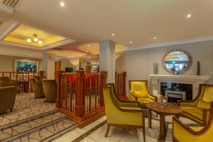 a living room with yellow chairs and a fireplace at The Malone in Belfast