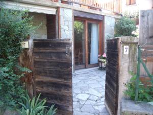 ein Eingang zu einem Haus mit einem Holztor in der Unterkunft studio a proximite des pistes in Saint-Chaffrey