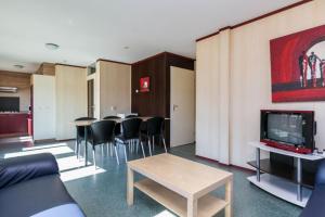 a room with tables and chairs and a tv at HH van Craenwick Appartement in De Hutte