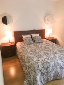 a bedroom with a bed with two lamps and a mirror at The River's Whisper Apartment in Geres