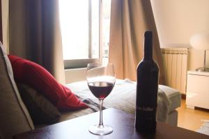 una botella de vino y una copa en una mesa en The River's Whisper Apartment en Geres
