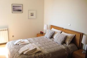 um quarto com uma cama com duas toalhas em The River's Whisper Apartment no Gerês