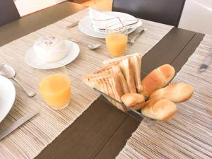 a table with a tray of bread and two glasses of orange juice at The River's Whisper Apartment in Geres