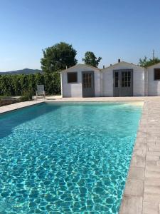 una piscina de agua azul frente a una casa en Evolution Camp, en SantʼIppolito