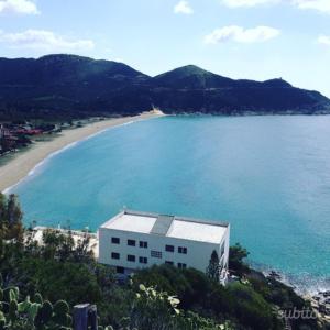 un edificio en una playa junto a un cuerpo de agua en Villa Solanas, en Solanas