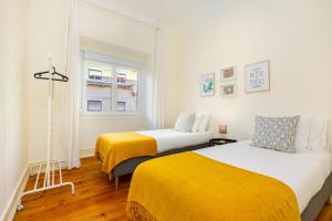 a bedroom with two beds and a window at WHome Hideaway Family Apartment #1 in Lisbon