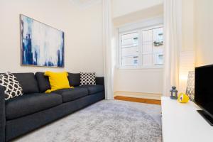 a living room with a couch and a window at WHome Hideaway Family Apartment #1 in Lisbon