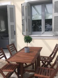 a wooden table with two chairs and a potted plant at Bakagiannis Apartments in Parga