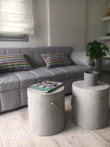 a living room with a couch and two ottomans at Bakagiannis Apartments in Parga