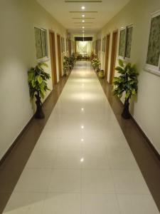 een lege hal in een gebouw met potplanten bij BnB Hotel in Lahore