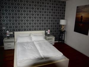 1 cama blanca en un dormitorio con pared en SC Apartment - Nürnberg Messe / Fränkisches Seenland en Schwabach