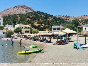 una playa con un grupo de personas y barcos en ella en Seaside Apartment-George, en Kalí Limenes
