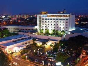 The Apo View Hotel في مدينة دافاو: مبنى أبيض كبير مع موقف للسيارات في الليل