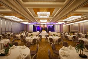 a banquet hall with white tables and chairs at Millennium Resort Salalah in Salalah +87 photos