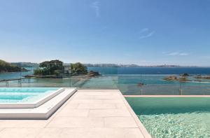 a swimming pool with a view of the water at Noa Boutique Hotel in Santa Cruz de Oleiros