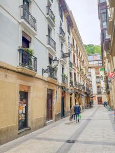 un grupo de personas caminando por una calle con edificios en Pension Aussie Guesthouse, en San Sebastián