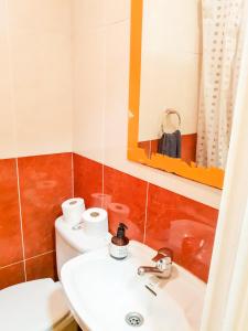 y baño con lavabo, aseo y espejo. en Pension Aussie Guesthouse, en San Sebastián