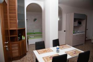 Zimmer mit einem Tisch, Stühlen und einem Bett in der Unterkunft Green Apartment in Rosolina Mare