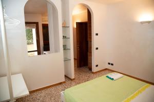 a bedroom with a green bed and a mirror at Green Apartment in Rosolina Mare