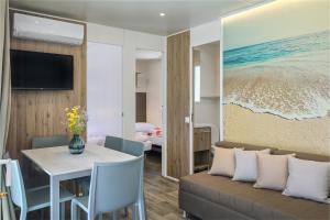 a living room with a couch and a table at Mobile Homes Camping Santa Marina, Lanterna in Poreč