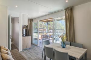 a dining room and kitchen with a table and chairs at Mobile Homes Camping Santa Marina, Lanterna in Poreč