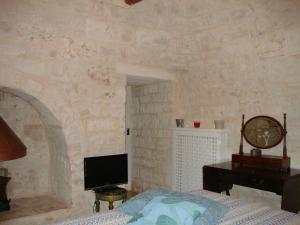 a bedroom with a bed and a tv on a wall at Fontana Vecchia B&B in Castellana Grotte
