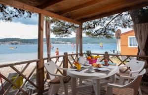 een tafel op een terras met uitzicht op het strand bij Mobile Homes Camp Perna - Adriatic Kampovi in Orebić