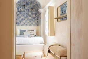 Schlafzimmer mit einem Bett mit blauen und weißen Fliesen in der Unterkunft Archi-Pelago Alfama Design Suites Guesthouse in Lissabon
