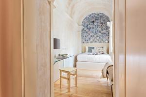 ein Schlafzimmer mit einem Bett und einem Tisch mit einem Stuhl in der Unterkunft Archi-Pelago Alfama Design Suites Guesthouse in Lissabon