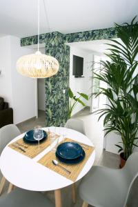 a dining room with a white table and chairs at MONKÓ - COCO & TROPYCAL APARTMENT o in Torremolinos