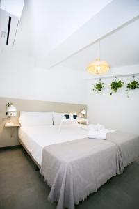 Habitación blanca con cama grande y lámpara de araña. en MONKÓ - COCO & TROPYCAL APARTMENT o, en Torremolinos