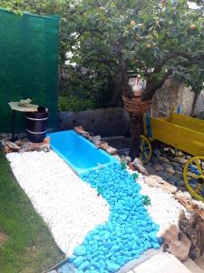una piscina en el patio trasero con rocas azules y un árbol en Guest House IDeR en Sapareva Banya