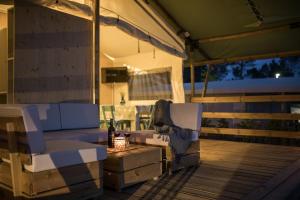 a patio with a couch and a chair on a deck at Mobile Homes Camping Santa Marina, Lanterna in Poreč