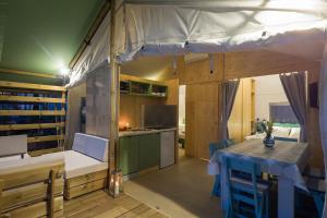 a kitchen with a table and a tent in a room at Mobile Homes Camping Santa Marina, Lanterna in Poreč