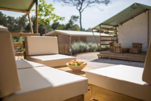 a table with two chairs and a bowl of fruit on it at Mobile Homes Camping Santa Marina, Lanterna in Poreč