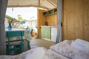 a room with a kitchen and a table and a bed at Mobile Homes Camping Santa Marina, Lanterna in Poreč +37 photos