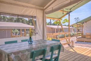 a table with a vase of flowers on a patio at Mobile Homes Camping Santa Marina, Lanterna in Poreč