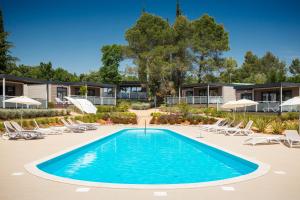 a swimming pool with lounge chairs and a resort at Mobile Homes Camping Santa Marina, Lanterna in Poreč