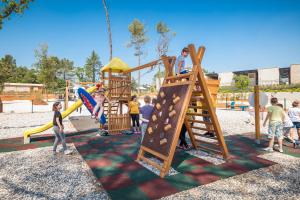 a group of children playing on a playground at Mobile Homes Camping Santa Marina, Lanterna in Poreč