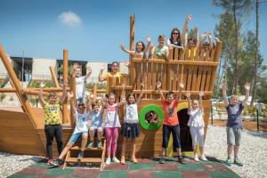 a group of children posing in front of a playground at Mobile Homes Camping Santa Marina, Lanterna in Poreč