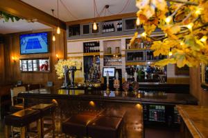 eine Bar mit braunen Ledersitzen und einem TV in der Unterkunft The Fitzrovia Belle Hotel in London