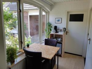 a kitchen with a table and chairs and a window at B&B Oostrik in Leende