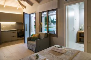a room with a bed and a chair and a kitchen at Alba Al Mare Villette in Laganas