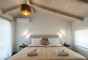 a bedroom with a large bed with two pillows on it at Alba Al Mare Villette in Laganas +31 photos
