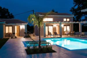 a villa with a swimming pool at night at Alba Al Mare Villette in Laganas