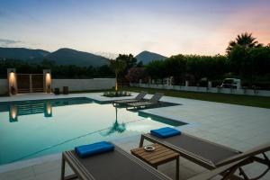 a swimming pool with two lounge chairs and a table at Alba Al Mare Villette in Laganas