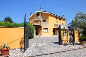 a yellow house with a black gate in front of it at Country House La Foggetta in Pineto